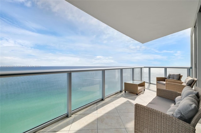 balcony with a water view and an outdoor living space