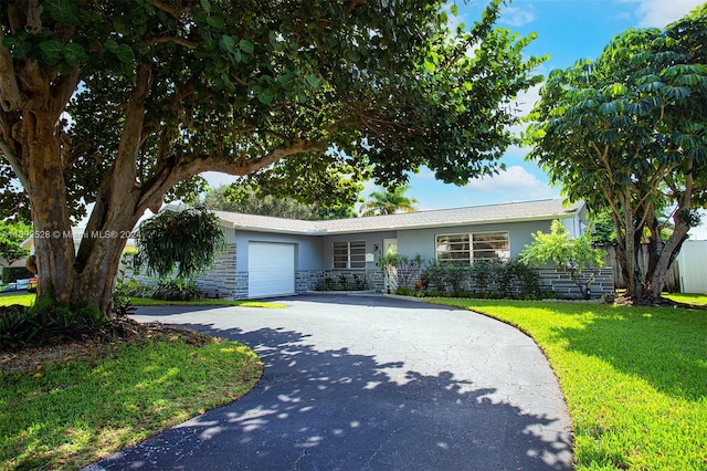 ranch-style house featuring a garage and a front yard