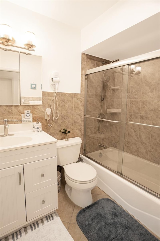 full bathroom featuring enclosed tub / shower combo, toilet, tile patterned floors, tile walls, and vanity