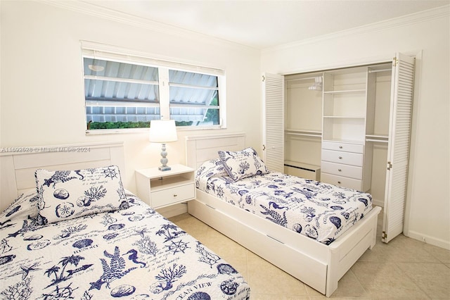 bedroom with a closet, light tile patterned floors, and crown molding