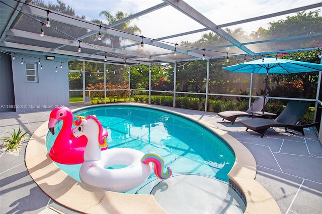 view of pool featuring glass enclosure and a patio area