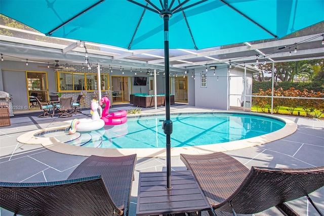 view of pool featuring ceiling fan, glass enclosure, and a patio area