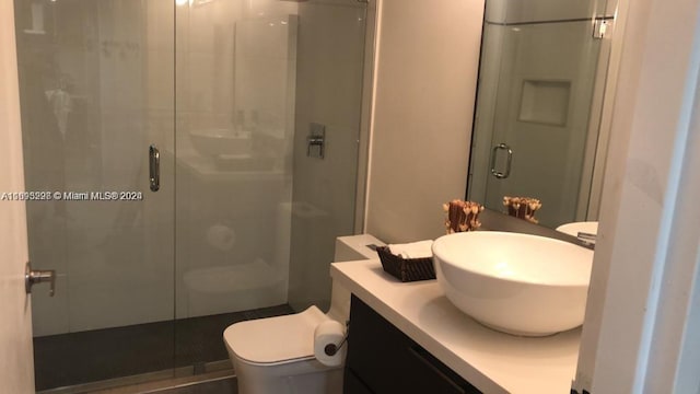 bathroom featuring walk in shower, vanity, and toilet