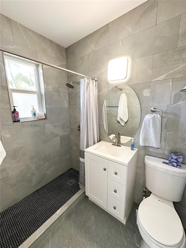 bathroom featuring a shower with shower curtain, vanity, toilet, and tile walls