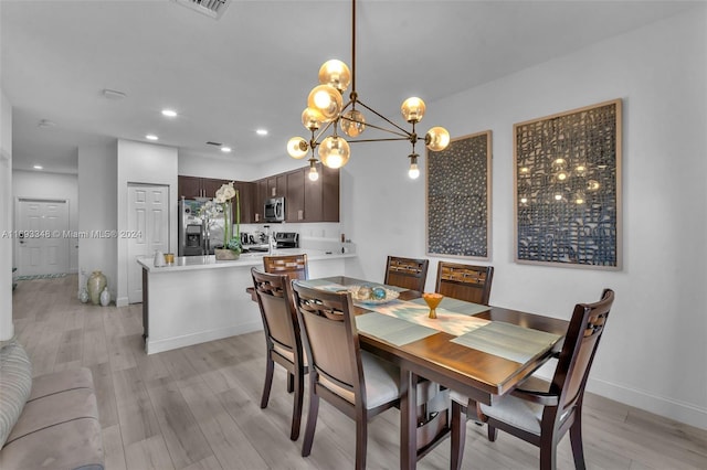 dining space with a notable chandelier and light hardwood / wood-style flooring