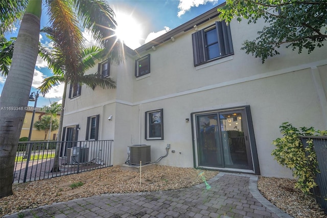 back of property with central air condition unit and a patio area