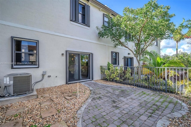 rear view of house featuring central AC unit and a patio