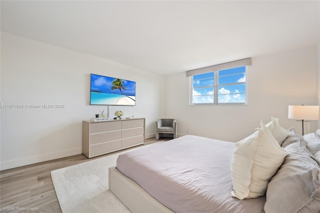 bedroom featuring light wood-style flooring and baseboards