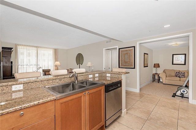 kitchen with stainless steel dishwasher, sink, light stone counters, and light tile patterned flooring