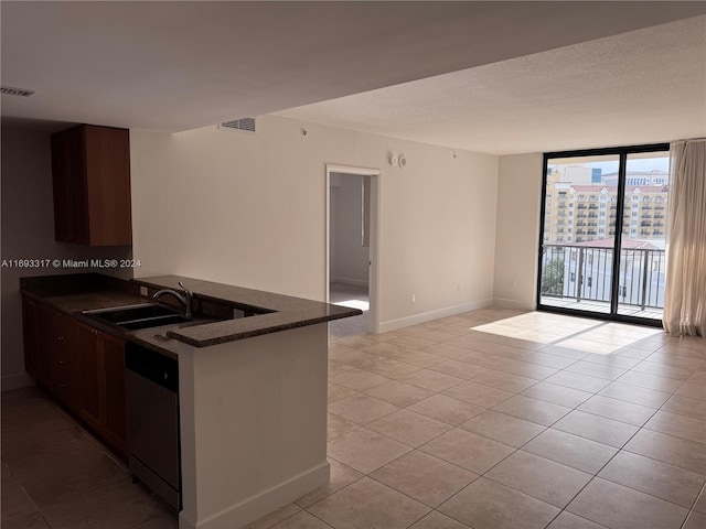 kitchen with dark brown cabinetry, stainless steel dishwasher, kitchen peninsula, and light tile patterned floors