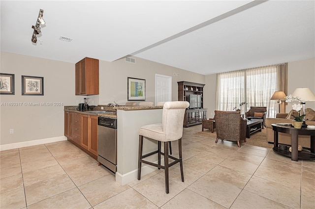 kitchen featuring dishwasher, kitchen peninsula, sink, and light tile patterned floors