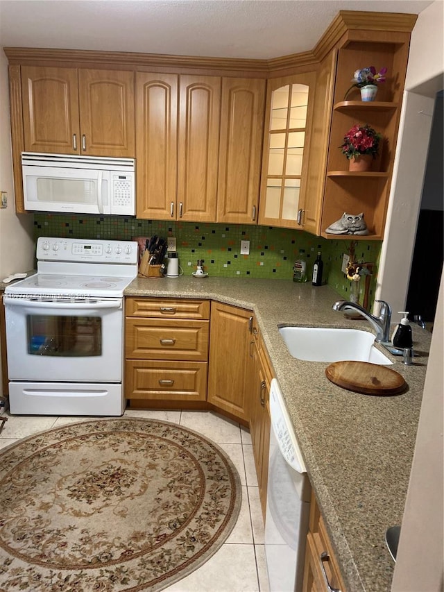 kitchen with light stone countertops, sink, backsplash, white appliances, and light tile patterned flooring