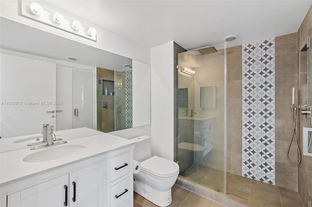 bathroom featuring toilet, vanity, an enclosed shower, and tile patterned floors