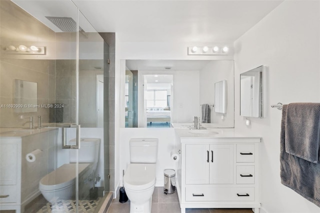 bathroom featuring tile patterned flooring, vanity, toilet, and a shower with door