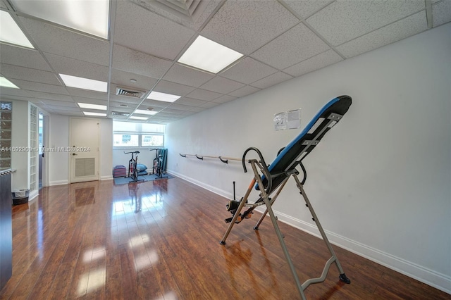 workout room featuring dark wood-type flooring and a paneled ceiling