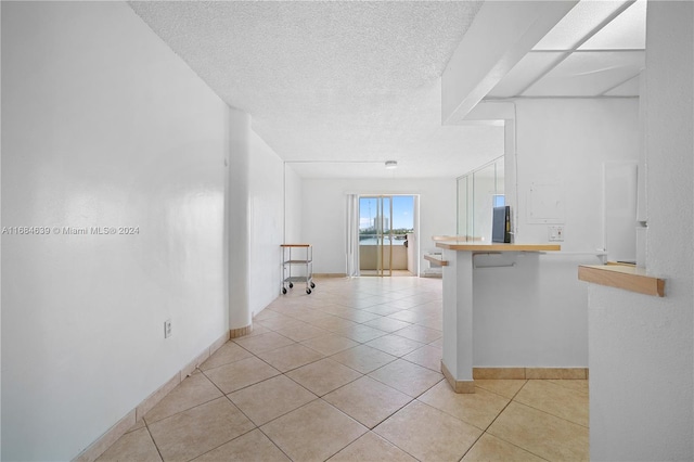 kitchen with kitchen peninsula, a kitchen bar, and light tile patterned floors