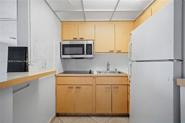 kitchen featuring light tile patterned floors, white fridge, sink, and black electric cooktop