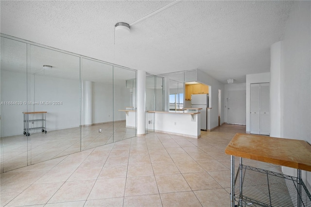 interior space featuring a textured ceiling and light tile patterned floors