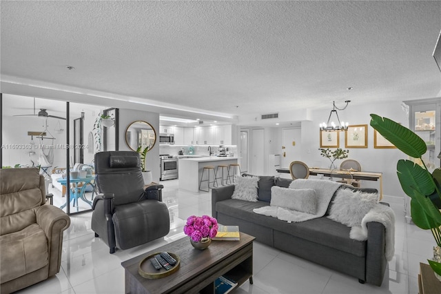 tiled living room featuring a notable chandelier and a textured ceiling