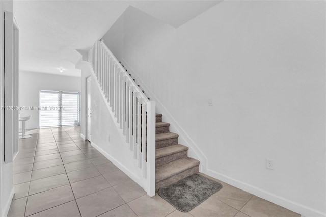 staircase featuring tile patterned flooring