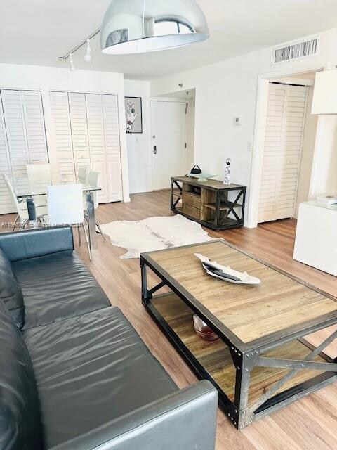 living room with track lighting and hardwood / wood-style flooring