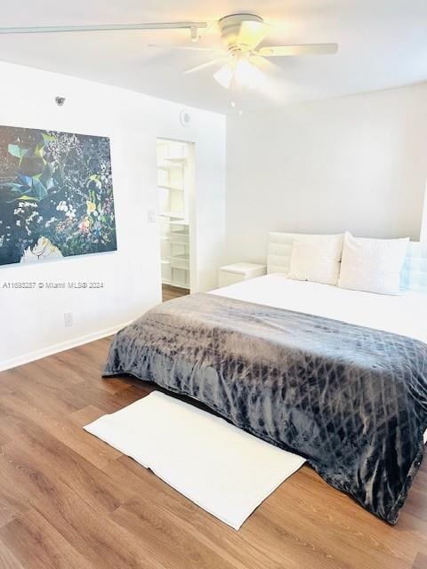 bedroom with hardwood / wood-style flooring, ensuite bath, and ceiling fan