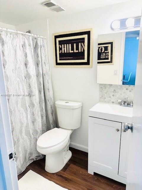 bathroom featuring hardwood / wood-style floors, vanity, toilet, and a shower with curtain