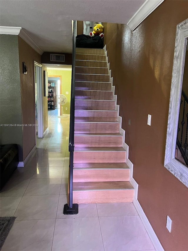 stairway with tile patterned flooring and ornamental molding