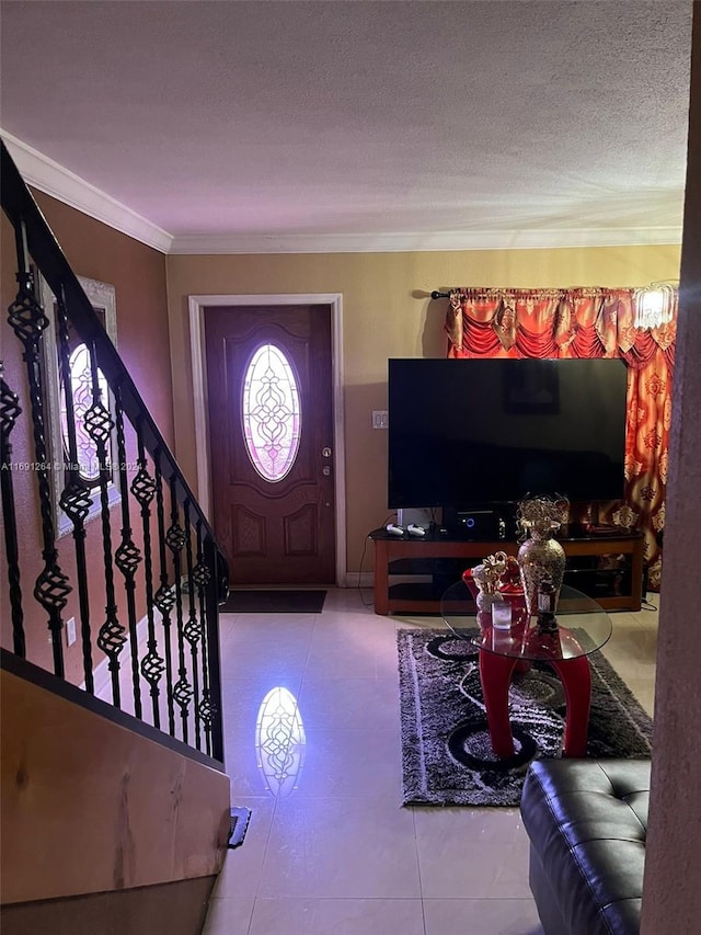 entrance foyer featuring a textured ceiling, tile patterned flooring, and ornamental molding