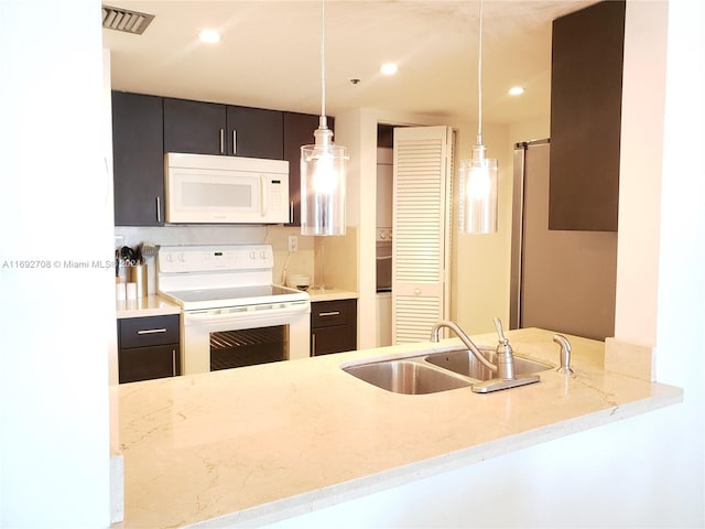 kitchen featuring sink, kitchen peninsula, light stone countertops, white appliances, and pendant lighting