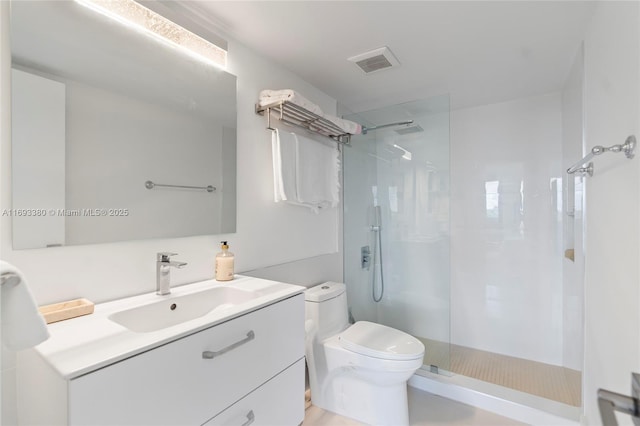 bathroom featuring toilet, vanity, and a shower