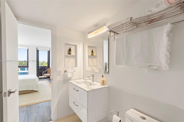 bathroom with toilet, vanity, and hardwood / wood-style flooring