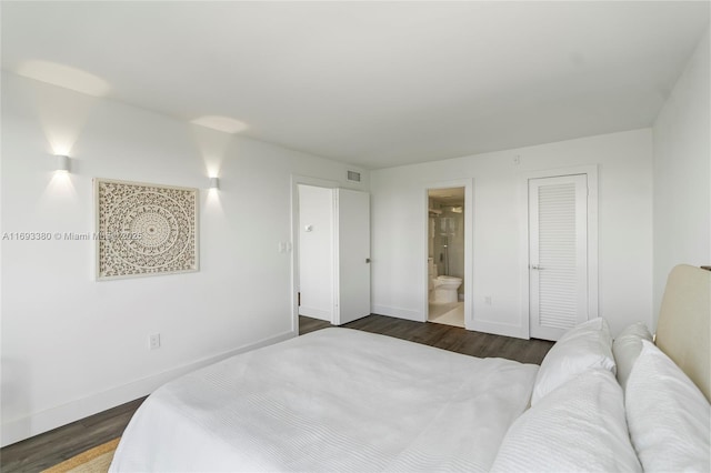 bedroom with dark hardwood / wood-style floors, a closet, and ensuite bath