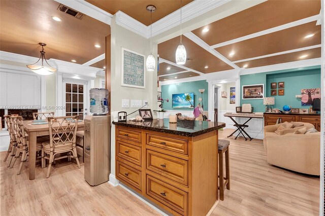 kitchen with decorative light fixtures, a kitchen bar, light wood-type flooring, and dark stone counters