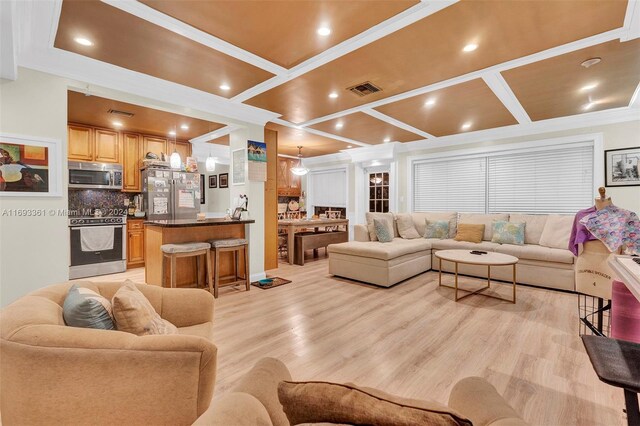 living room featuring ornamental molding, coffered ceiling, and light wood-type flooring