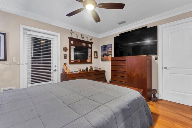 bedroom with ceiling fan, hardwood / wood-style floors, and crown molding