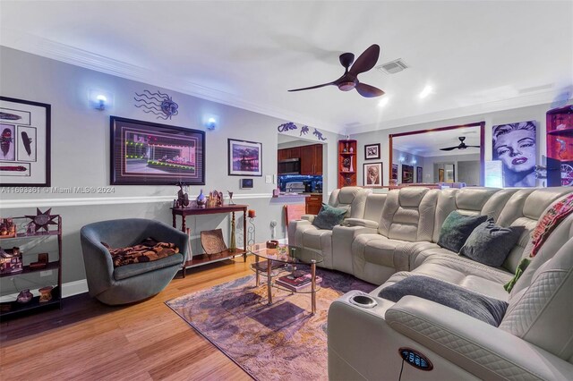 living room featuring ceiling fan, wood-type flooring, and ornamental molding