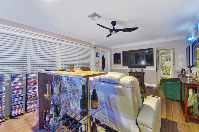 dining area featuring wood-type flooring, ceiling fan, and crown molding