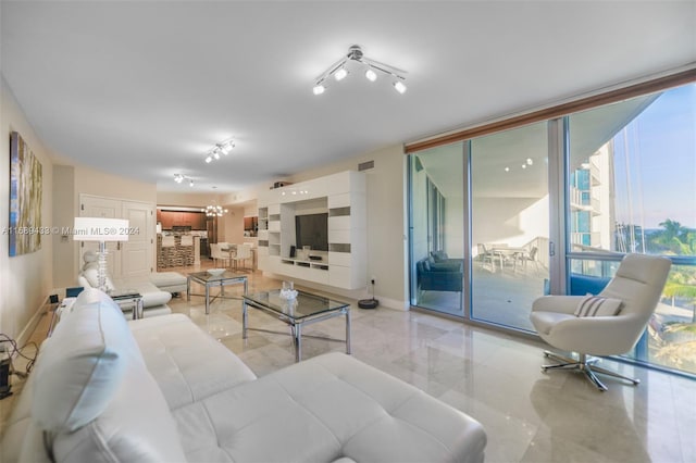 living room with floor to ceiling windows and a chandelier