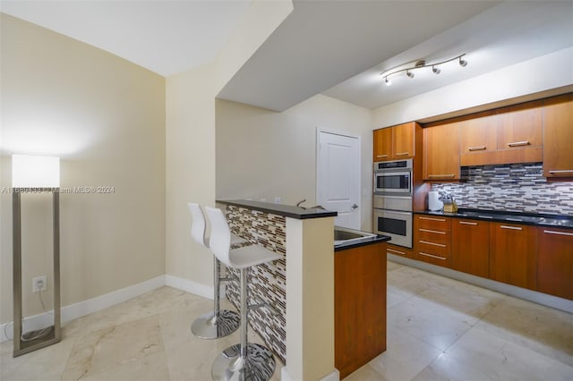 kitchen with backsplash, black gas stovetop, and stainless steel double oven