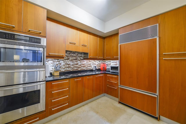 kitchen featuring decorative backsplash, paneled built in fridge, black gas stovetop, and stainless steel double oven