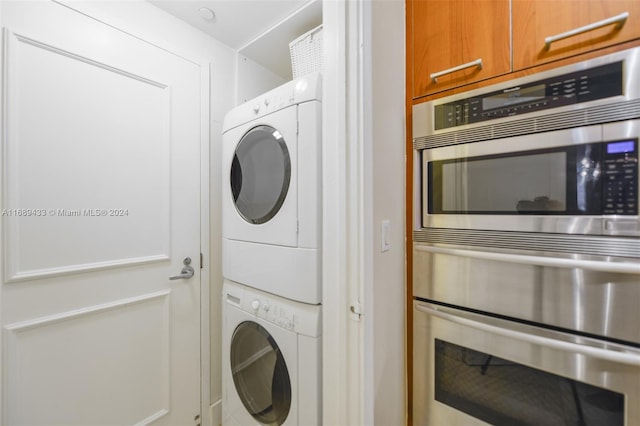 laundry room with cabinets and stacked washing maching and dryer