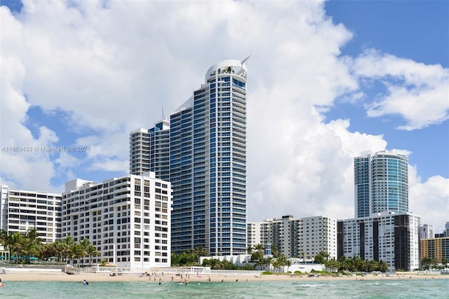 view of building exterior featuring a water view and a view of the beach