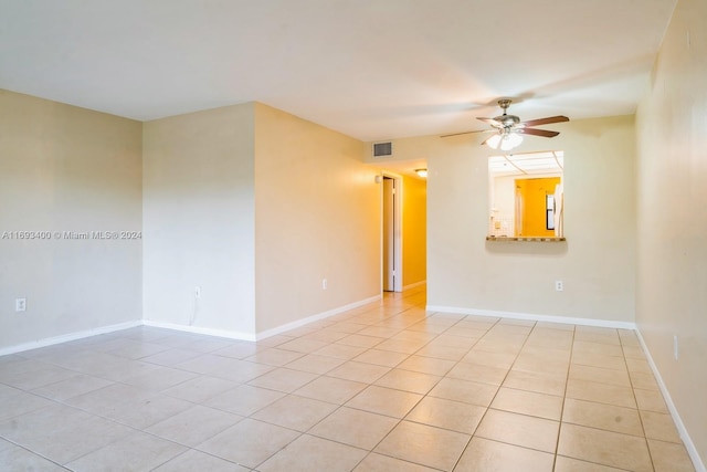 tiled spare room with ceiling fan