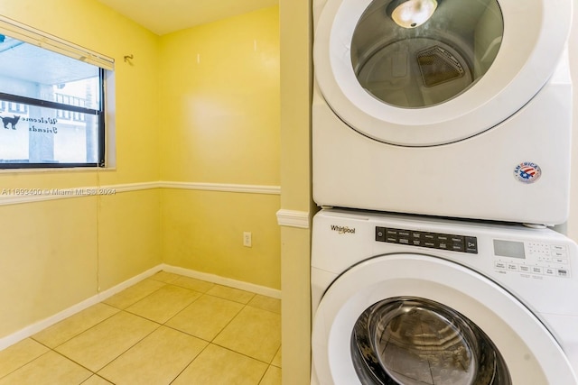 laundry area with tile patterned flooring and stacked washer and dryer