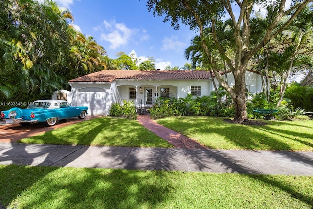 mediterranean / spanish-style house with a front lawn, a porch, and a garage