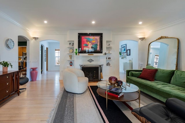 living room with ornamental molding and light hardwood / wood-style flooring