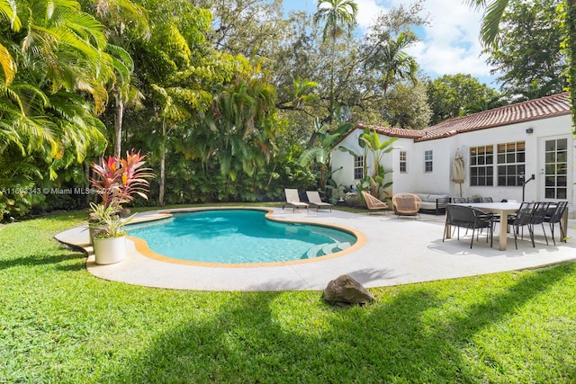 view of swimming pool with outdoor lounge area, a patio area, and a lawn