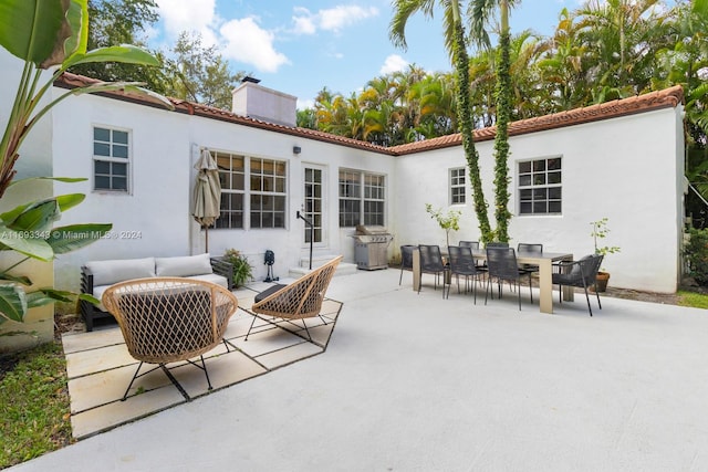 back of property with an outdoor living space and a patio area