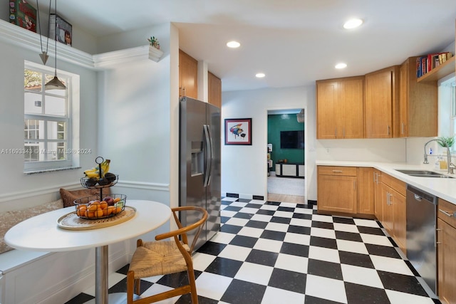 kitchen featuring sink, stainless steel appliances, and decorative light fixtures